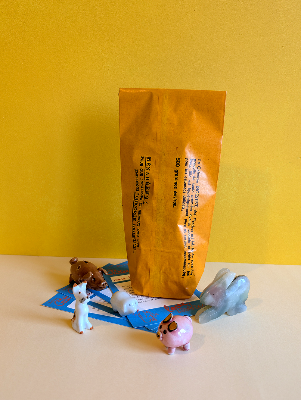 Small animal figurines around a blind box bag on a yellow background