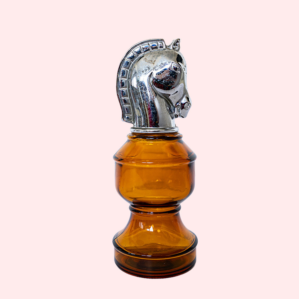 Amber glass bottle with a silver horse head stopper.
