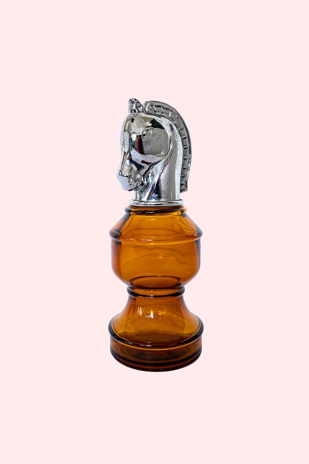Amber glass bottle with a silver horse head stopper.