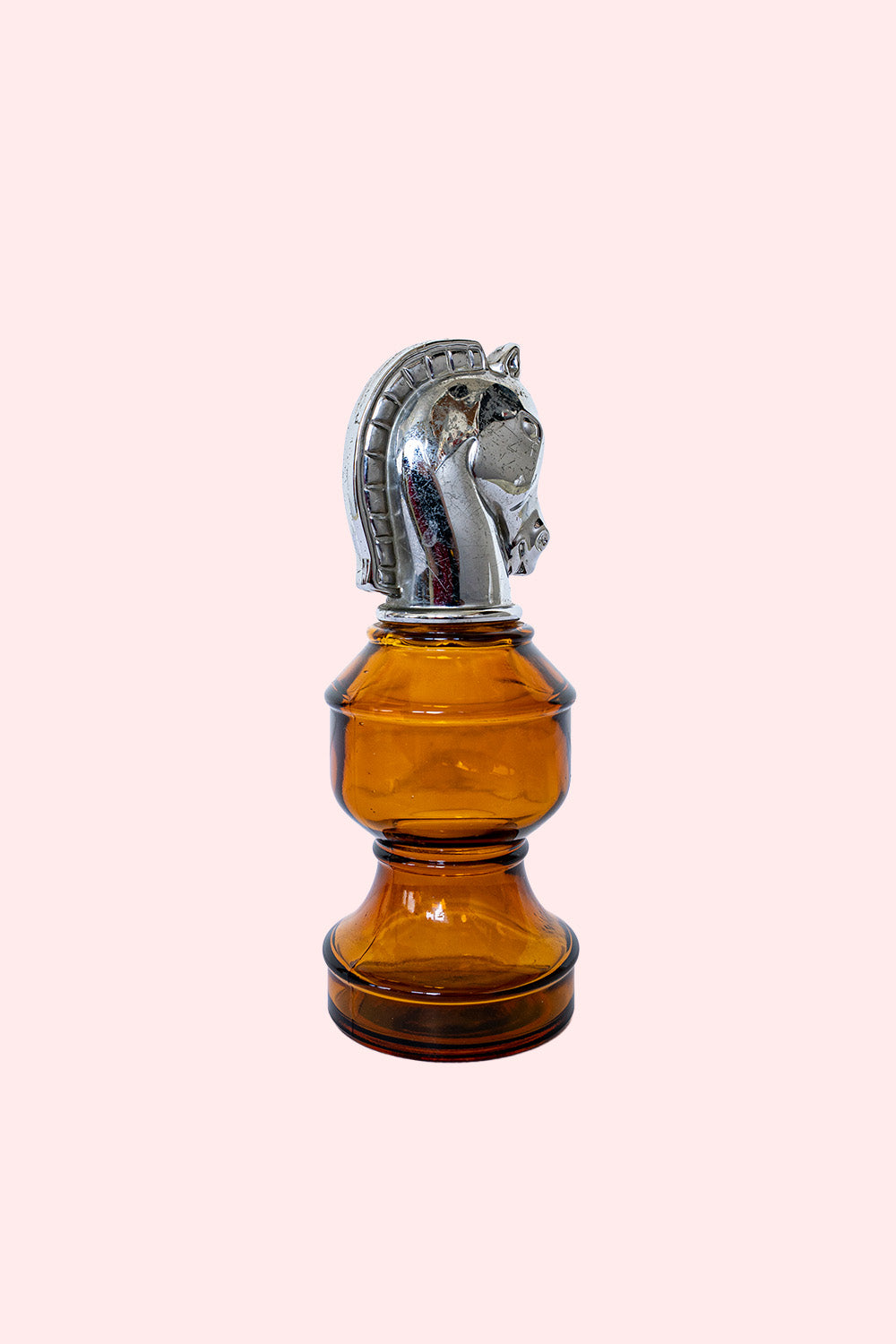 Amber glass bottle with a silver horse head stopper.
