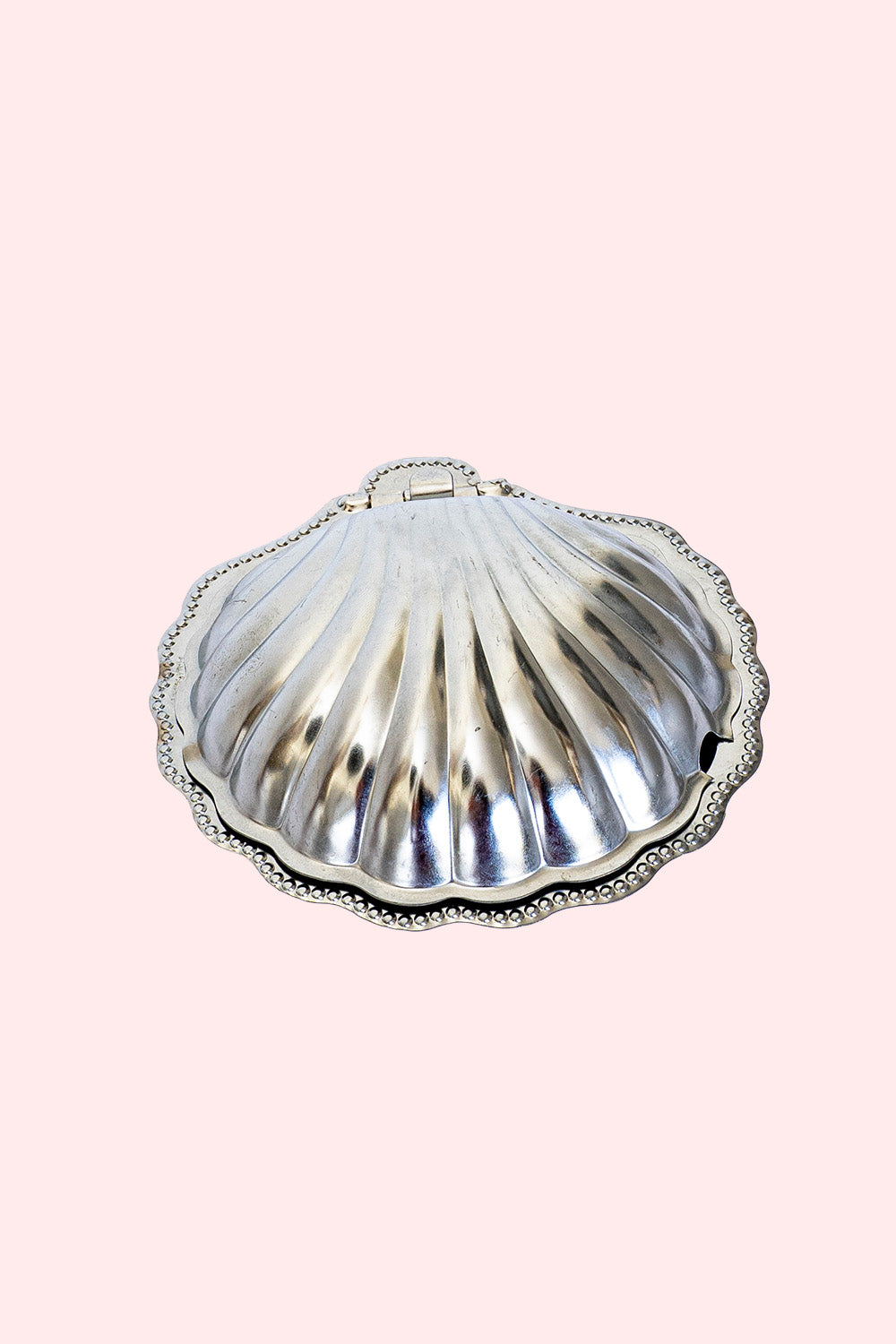 A silver butter dish in the shape of a shell. It can be used as a trinket tray. 