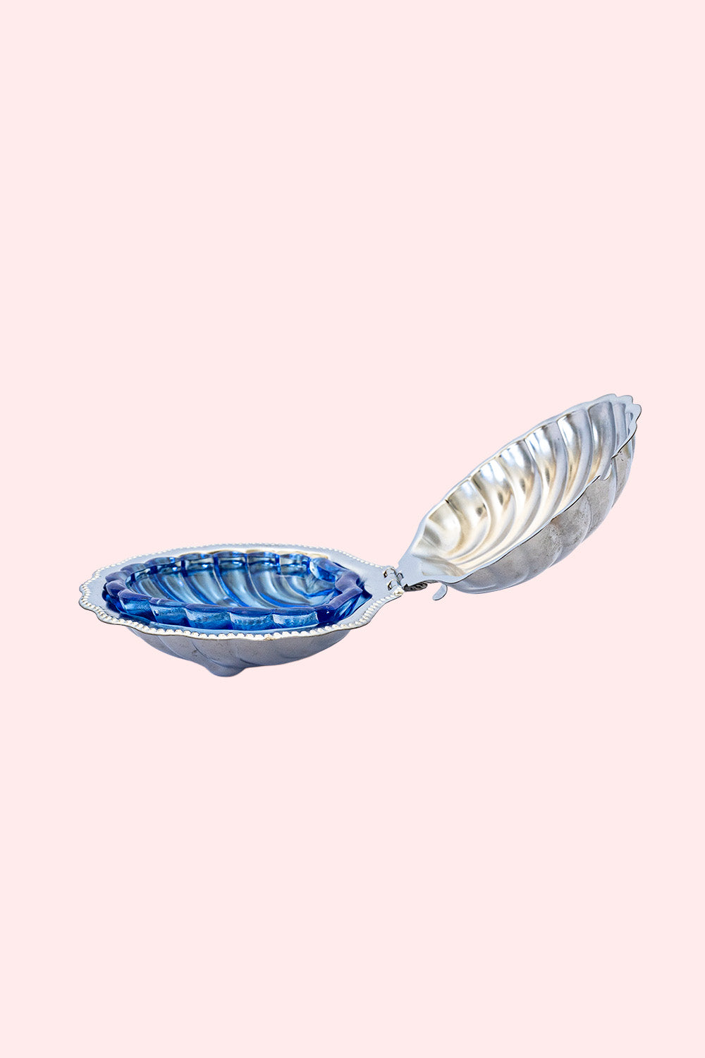 A silver butter dish in the shape of a shell with a blue glass part inside. It can be used as a trinket tray. 