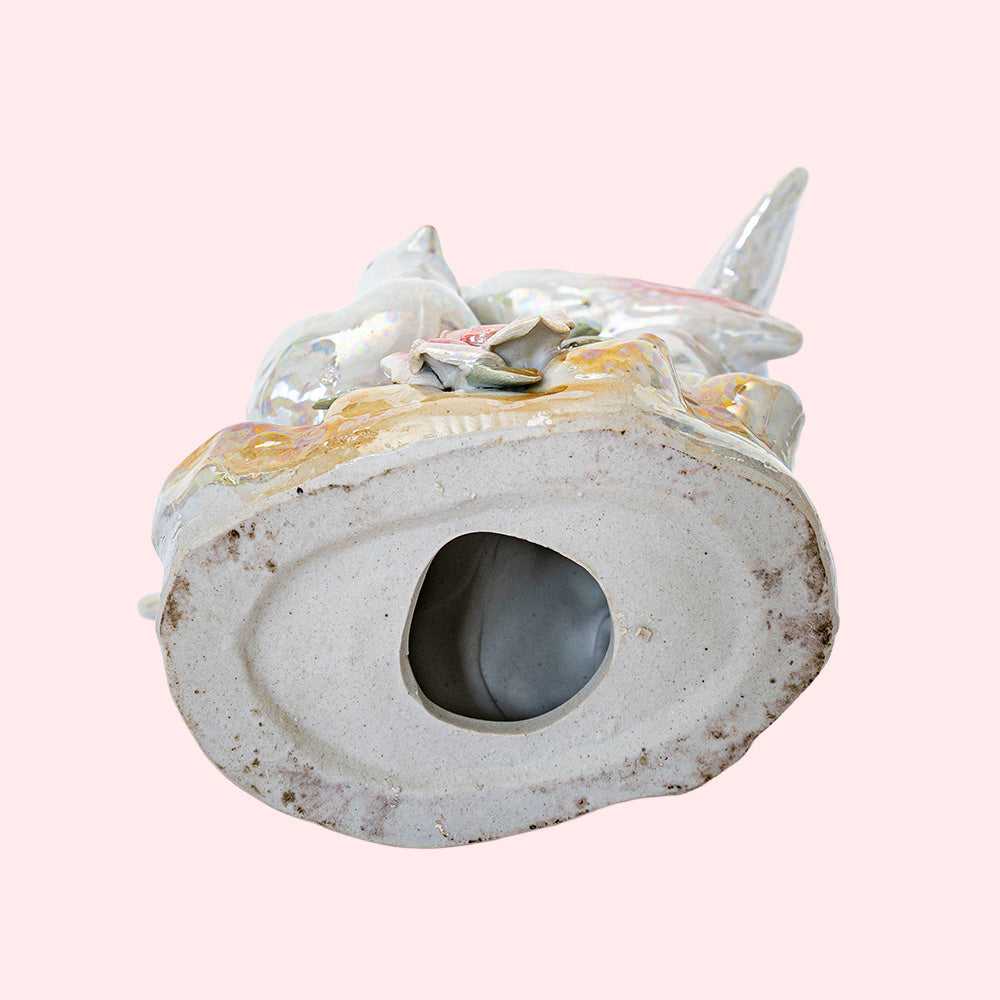 Second-hand, decorative ceramic figurine representing two doves with colorful wings and tails. It has an iridescent glaze. Seen from the underside.