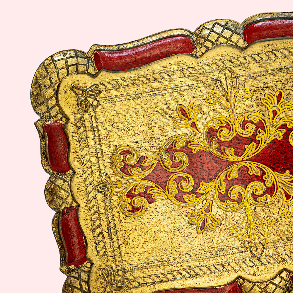 Vintage decorative gold and red rectangular plate with intricate patterns.