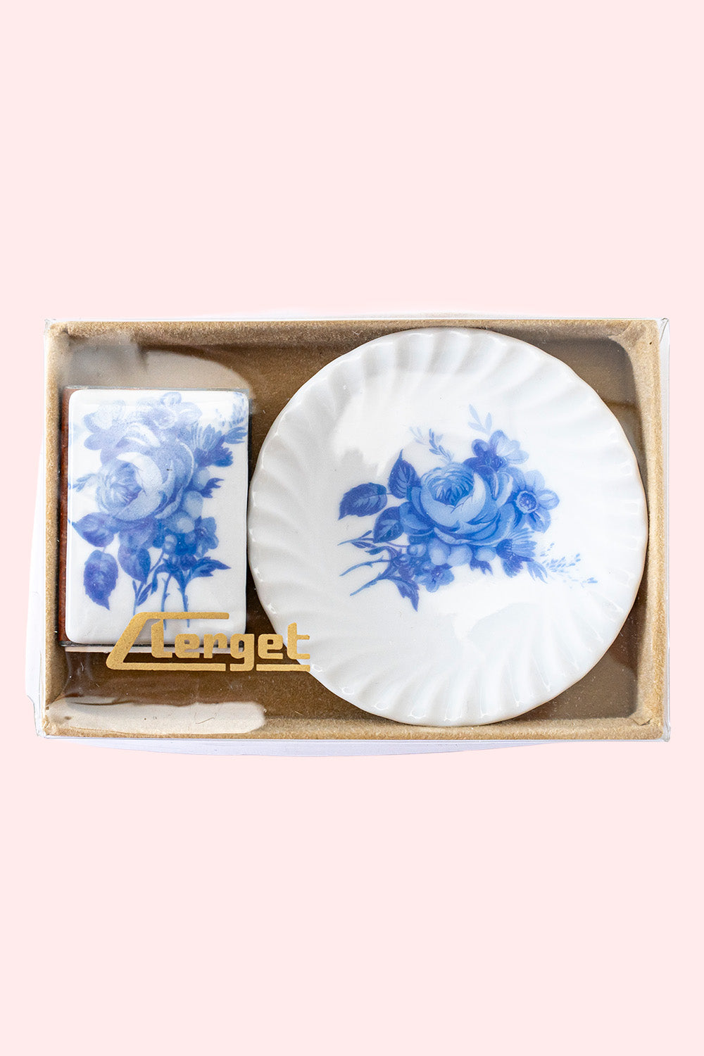 A vintage set of a porcelain plate and matchbox with a porcelain plating, both white with blue flowers. They sit in their original box.