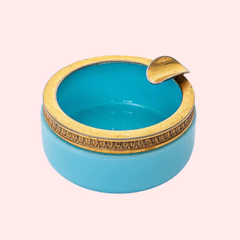A vintage blue opaline ashtray with a golden rim.