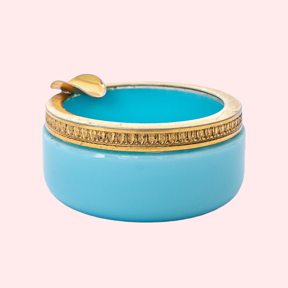 A vintage blue opaline ashtray with a golden rim.
