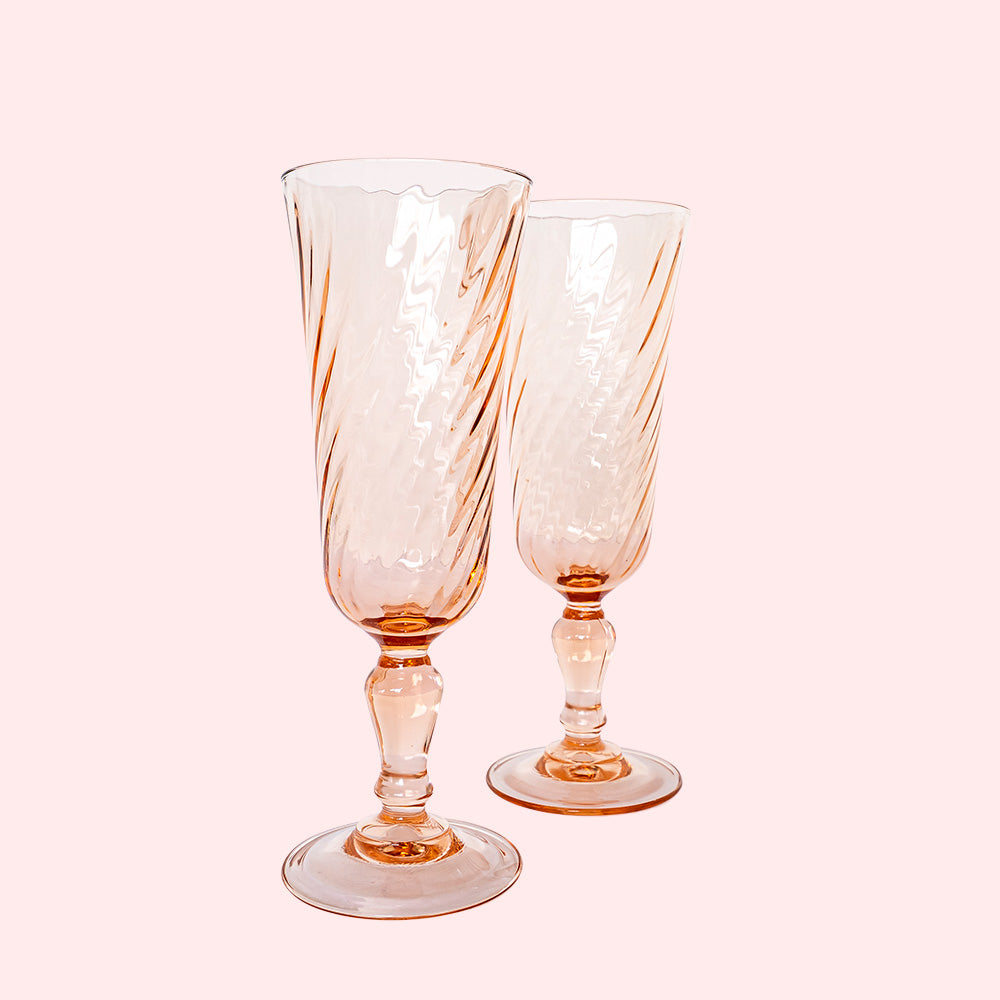 Two vintage pink champagne flutes with a swirl design.