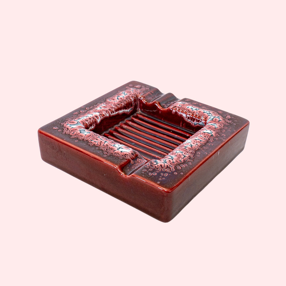 Decorative red ceramic ashtray with a ridged inside surface.