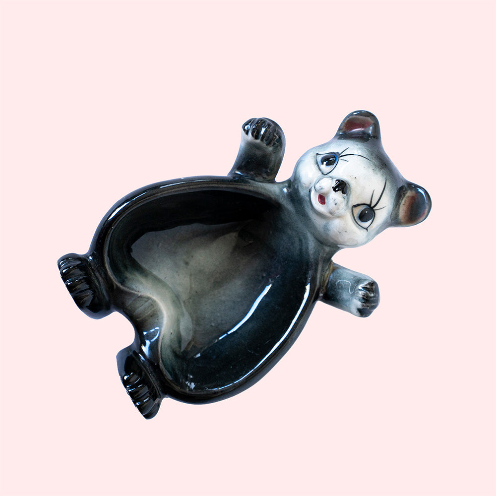 Second hand vintage trinket dish. It represents a black bear with a grey-white face, with his arms open. 